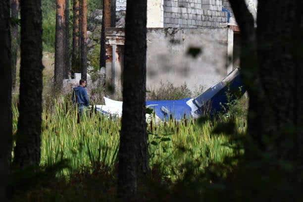 A law enforcement officer works at the site of a plane crash near the village of Kuzhenkino, Tver region, on 24 August 2023 (AFP via Getty Images)