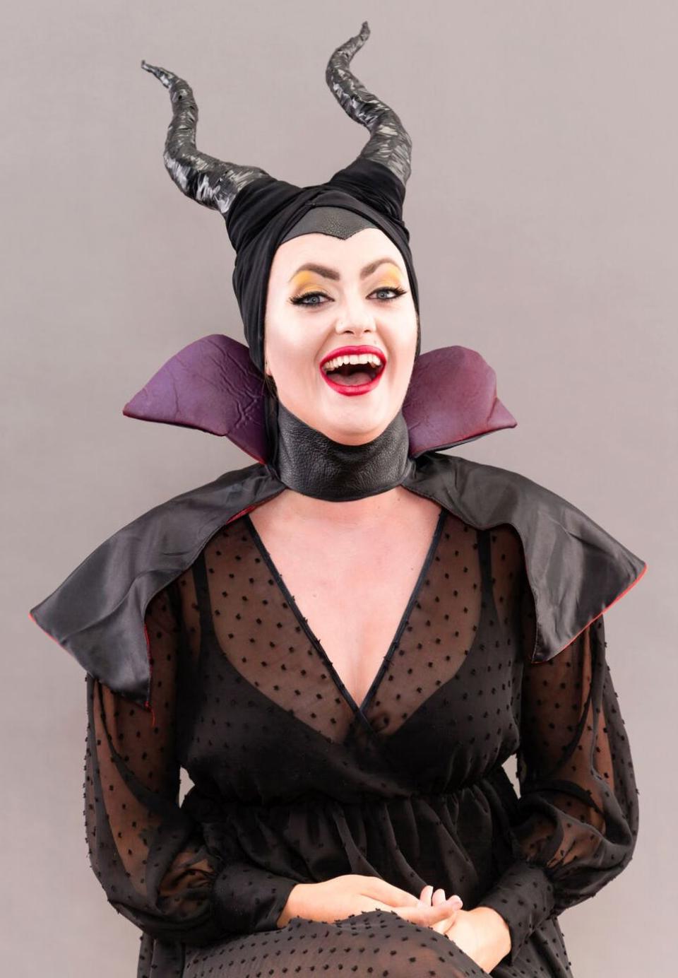 Woman dressed as Maleficent laughing.