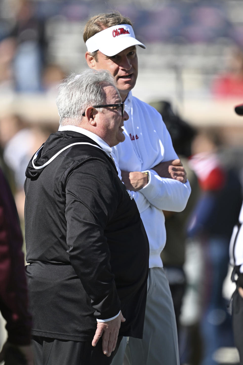 Louisiana Monroe head coach Terry Bowden, front, and Mississippi head coach Lane Kiffin talk before an NCAA college football game in Oxford, Miss., Saturday, Nov. 18, 2023. (AP Photo/Thomas Graning)