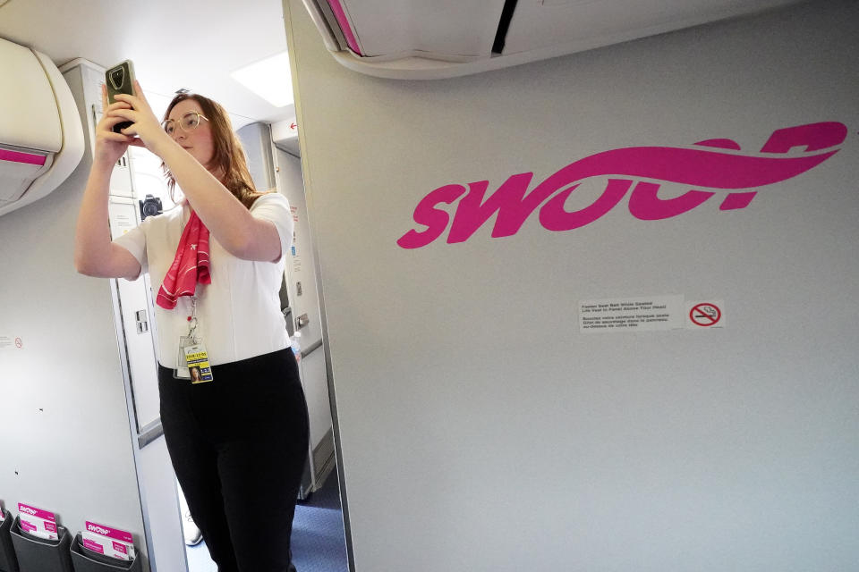 Employees walk onto a plane during a presentation by WestJet celebrating Canada's first ultra low cost airline, Swoop, at John C. Munro Hamilton International Airport in Hamilton, Ontario, Canada, June 19, 2018.  REUTERS/Carlo Allegri