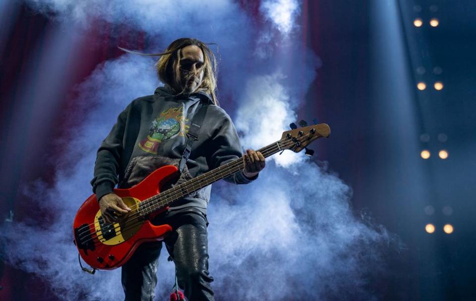 Fall Out Boy’s Pete Wentz plays the bass as smoke from an explosion fills the backdrop during the group’s concert Sunday at Golden 1 Center.