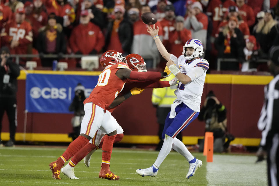 Buffalo Bills quarterback Josh Allen, right, stays in bounds as he throws under pressure during the second half of an NFL football game against the Kansas City Chiefs Sunday, Dec. 10, 2023, in Kansas City, Mo. (AP Photo/Charlie Riedel)