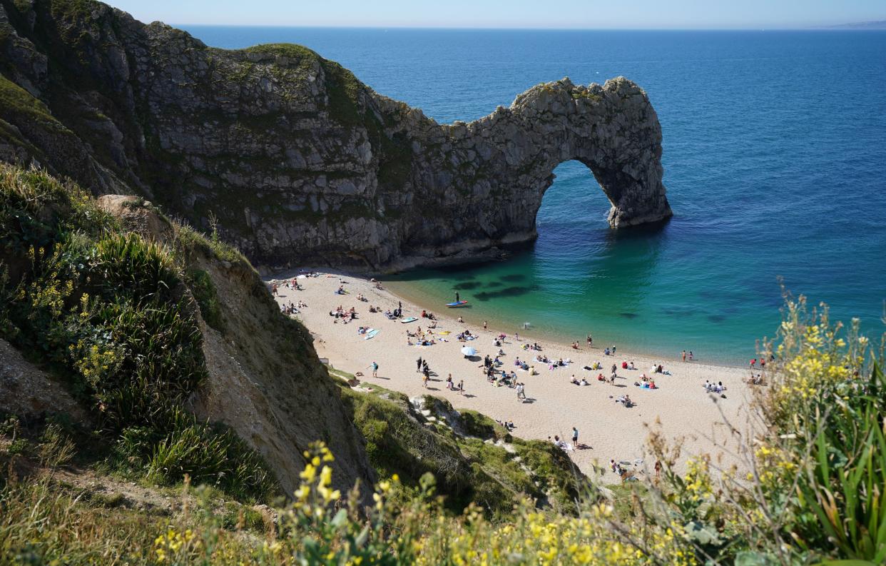 Dorset Police said the woman, who has not been identified, was pronounced dead at the scene (pictured: Durdle Door in early June) (PA)