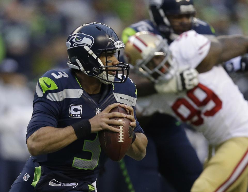 Seattle Seahawks' Russell Wilson looks to pass during the first half of the NFL football NFC Championship game against the San Francisco 49ers Sunday, Jan. 19, 2014, in Seattle. (AP Photo/Marcio Jose Sanchez)