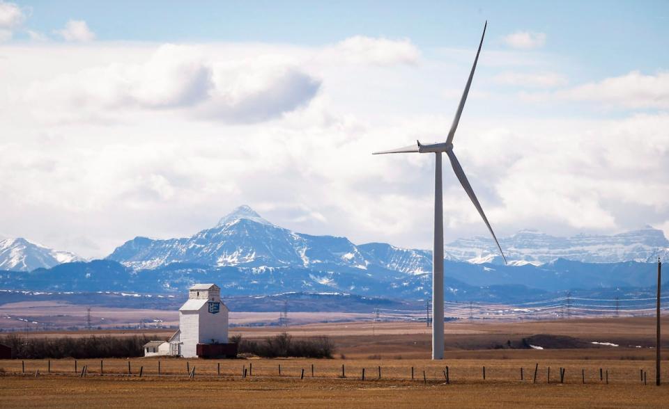 A wind turbine overshadows a grain elevator near Pincher Creek, Alta., on March 9, 2016.