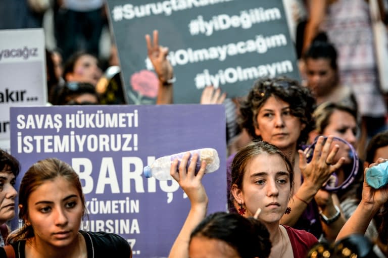 Women hold placards reading "We don't want a War Goverment - Peace" during an anti-war demonstration on August 19, 2015 in Istanbul