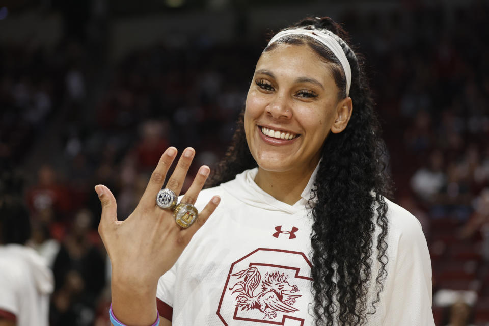 FILE - South Carolina center Kamilla Cardoso shows off her rings as the 2022 women's national championship team receive their rings before an an NCAA college basketball game in Columbia, S.C., Nov. 7, 2022. South Carolina 6-foot-7 center Kamilla Cardoso has been content the past two seasons playing in the shadow of All-American teammate Aliyah Boston. Now, Cardoso must step into the spotlight and be as dominant as Boston if the Gamecocks hope to continue contending for championships. It's a role Cardoso's coach Dawn Staley, her teammates and others say she's been building toward the past few years. (AP Photo/Nell Redmond, File)