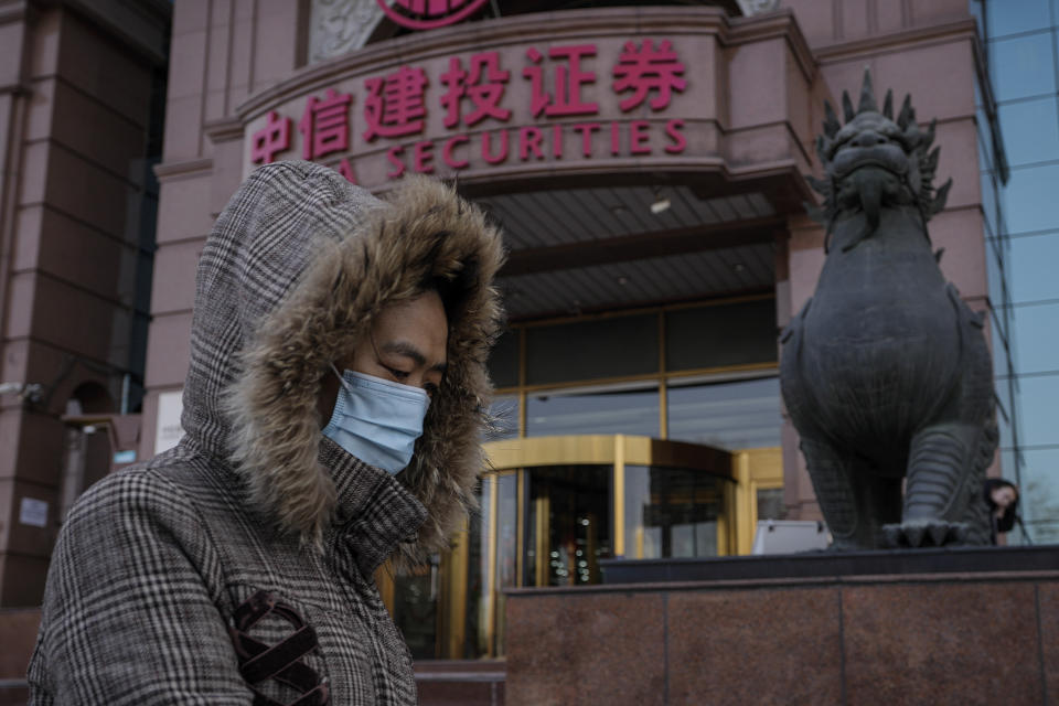 A woman walks by a brokerage house in Beijing, Tuesday, Feb. 6, 2024. A Chinese state investment fund has promised to expand its purchases of stock index funds to help markets that have been sagging under heavy selling pressure from a property crisis and slowing economy. (AP Photo/Andy Wong)