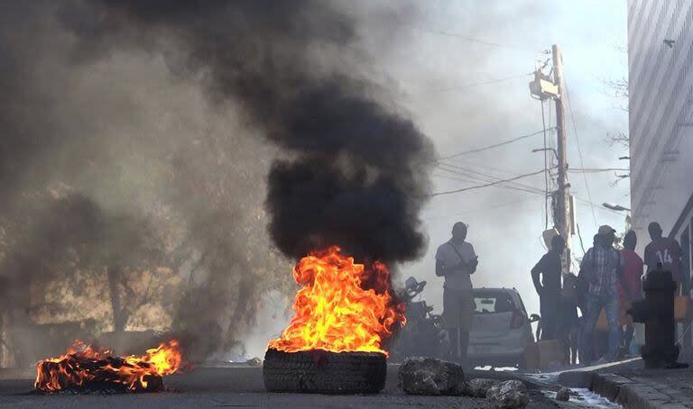 Esta captura de pantalla tomada de AFPTV muestra neumáticos en llamas cerca de la prisión principal de Puerto Príncipe, Haití, el 3 de marzo de 2024, después de una fuga de varios miles de reclusos
