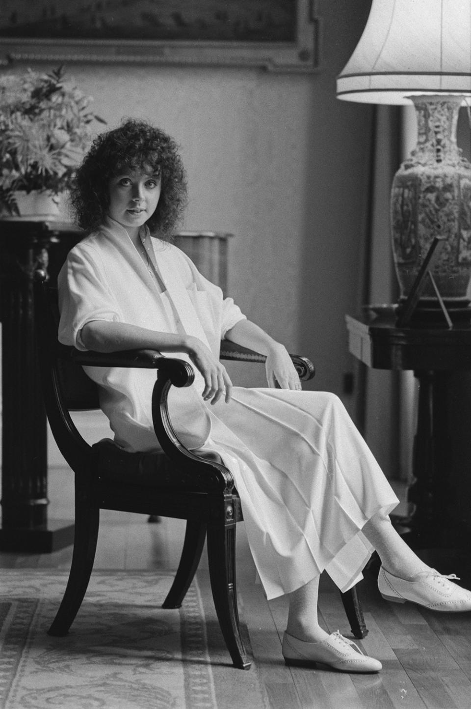 British soprano Sarah Brightman sitting in a chair, her arms on the armrests, United Kingdom, 1st April 1985. (Photo by Rogers/Daily Express/Hulton Archive/Getty Images)