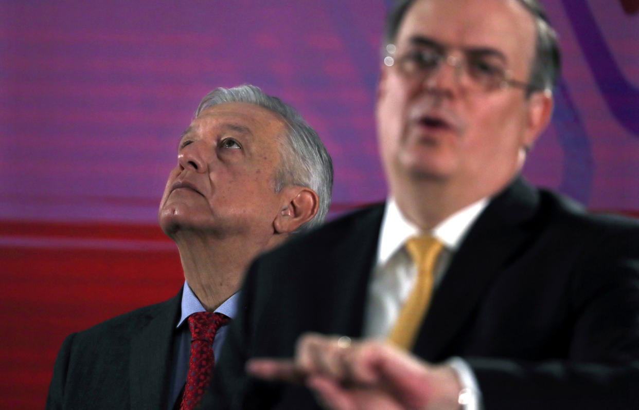 Mexican President Andres Manuel Lopez Obrador looks up as his Foreign Minister, Marcelo Ebrard, speaks during the president's daily morning press conference at the National Palace in Mexico City, Tuesday, Nov. 12, 2019. Bolivia's former President Evo Morales flew out of Bolivia on a Mexican government plane late Monday hours after being granted asylum. (AP Photo/Marco Ugarte)