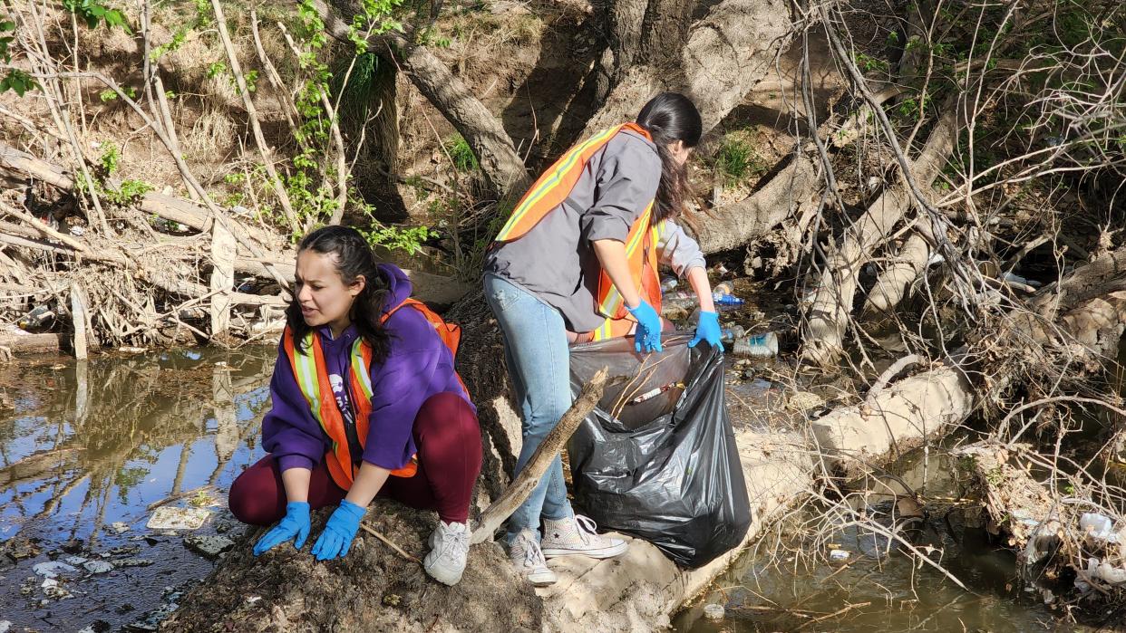 Volunteers clean up trash at Thompson Park during the cleanup event held in honor of Earth Day.