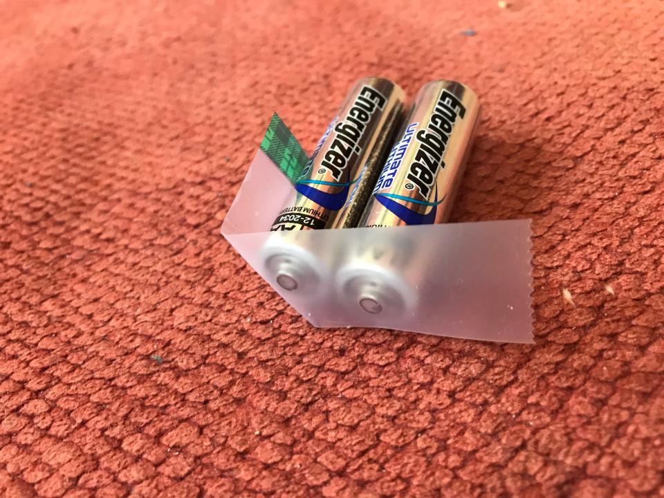 Clear tape covers the positive terminals of two lithium AA batteries on Feb. 12, 2021.
The tape helps reduce the risk of fire when batteries are stored at home — but recyclers caution against obscuring any identifying marks that typically help the sorting process.