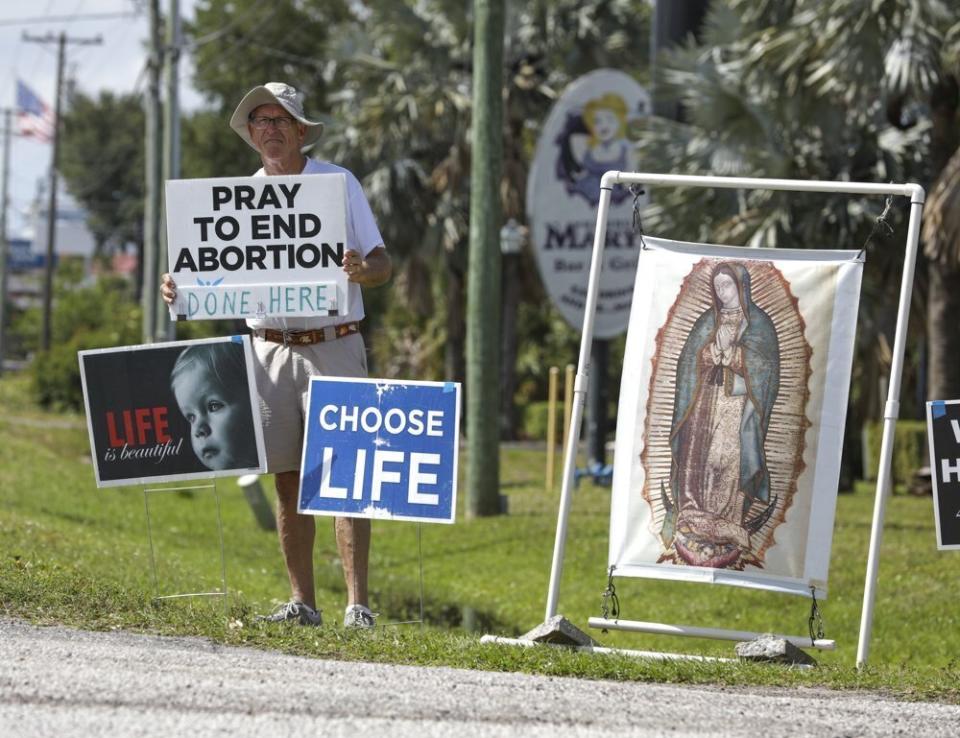 FILE - Dave Behrle, 70, of Safety Harbor holds a sign while standing outside the All Women's Health Center of Clearwater on May 3, 2022. (Chris Urso/Tampa Bay Times via AP, file)