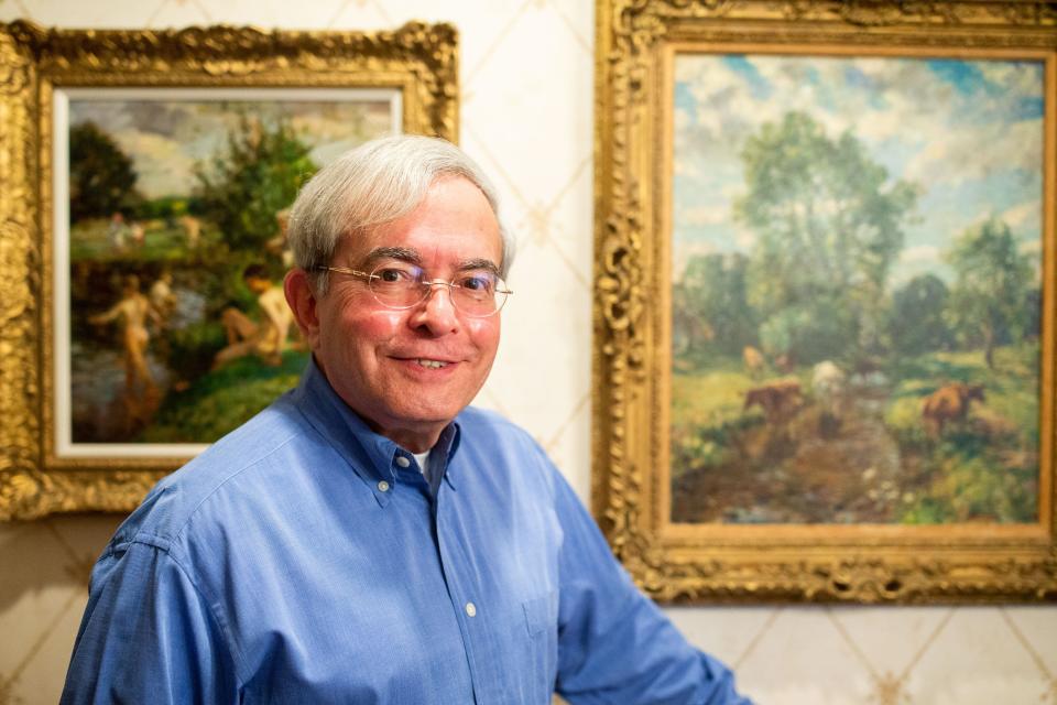 Segundo J. Fernandez photographed in front of paintings by William Mark Fisher R.A. (1843-1923), American impressionist, in his home on Thursday, Oct. 5, 2023.