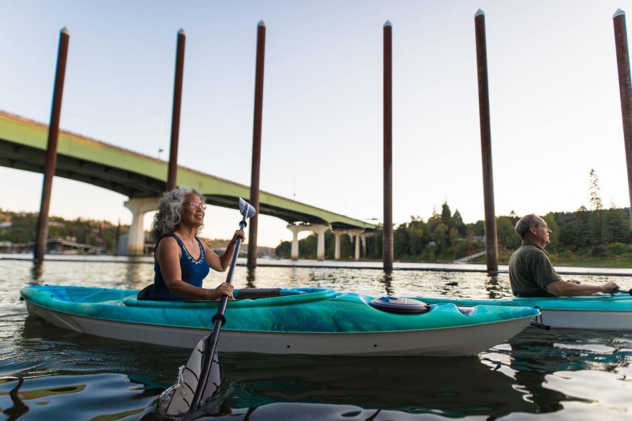 Older mature couple kayaking together during summer