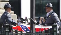 <p>An honor guard from the South Carolina Highway Patrol lowers the Confederate battle flag as it is removed from the Capitol grounds, Friday, July 10, 2015, in Columbia, S.C. The move was a stunning political reversal in a state where many thought the rebel banner would fly indefinitely. (Photo: John Bazemore/AP) </p>