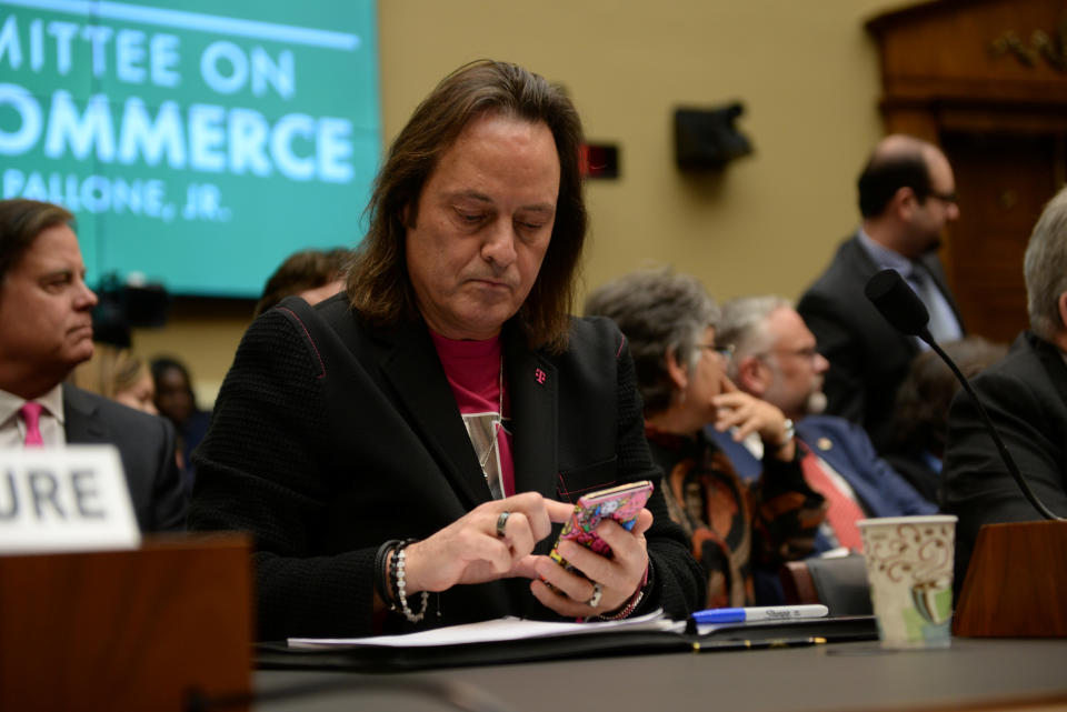 T-Mobile US CEO John Legere checks his phone before testifying before a U.S. House Committee on Energy and Commerce Subcommittee hearing in Washington, U.S. February 13, 2019. REUTERS/Erin Scott