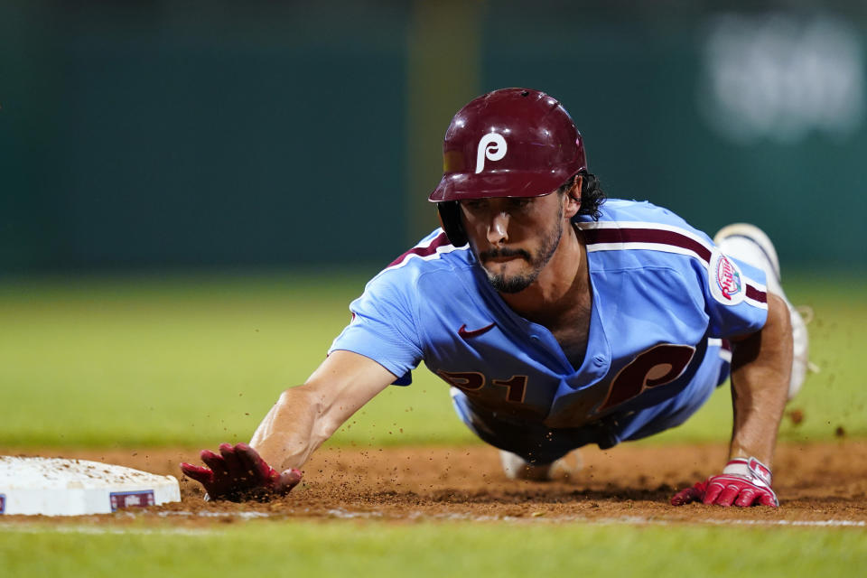 Philadelphia Phillies' Garrett Stubbs dives back to first on a pickoff attempt by Cincinnati Reds pitcher Justin Dunn during the fifth inning of a baseball game, Thursday, Aug. 25, 2022, in Philadelphia. (AP Photo/Matt Slocum)