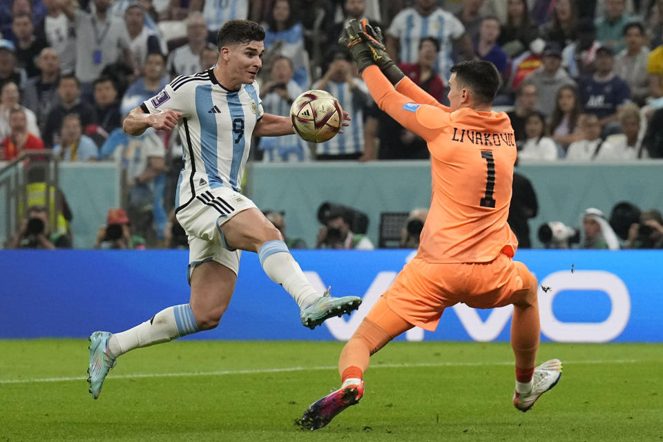 Argentina's Julian Alvarez, left, is fouled by Croatia's goalkeeper Dominik Livakovic during the World Cup semifinal soccer match between Argentina and Croatia at the Lusail Stadium in Lusail, Qatar, Tuesday, Dec. 13, 2022. (AP Photo/Martin Meissner)