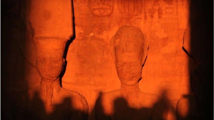 The sun illuminating ancient stone sculptures in an ancient temple in Egypt.
