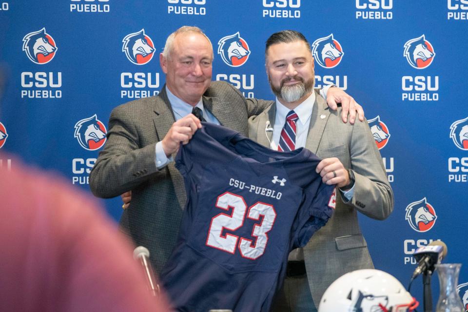 John Wristen, left, presents Philip Vigil with a jersey during a press conference announcing Vigil as the new head football coach of Colorado State University Pueblo on Tuesday, Jan. 3, 2023.