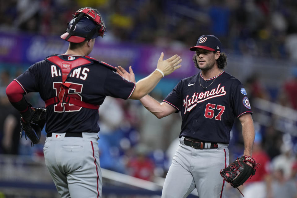 Washington Nationals relief pitcher Kyle Finnegan (67) and catcher Riley Adams (15) congratulate each other after the Nationals beat the Miami Marlins 3-2 during a baseball game, Saturday, Aug. 26, 2023, in Miami. (AP Photo/Wilfredo Lee)