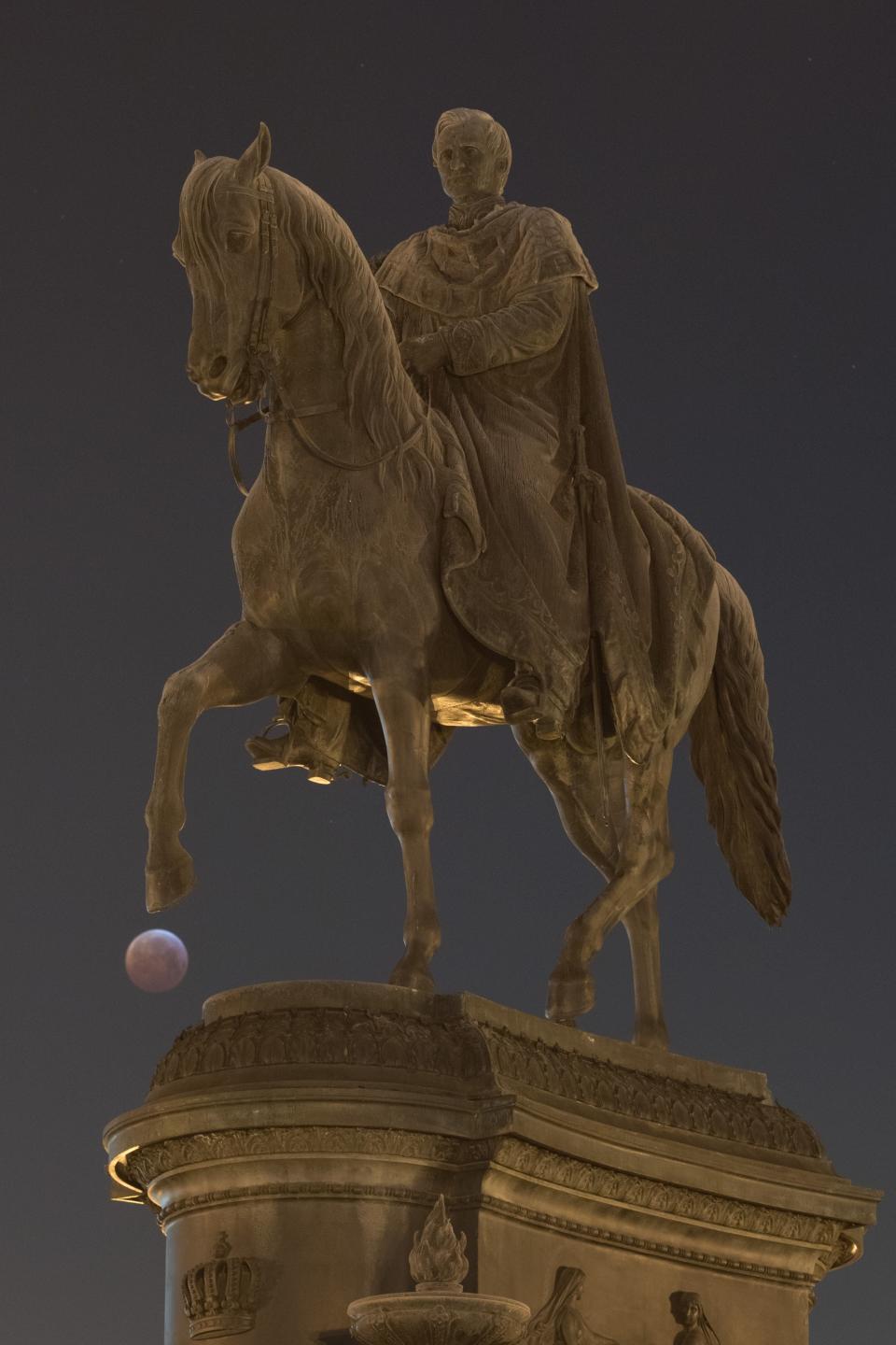 The super blood moon behind the equestrian statue of the Saxon king Johann in Dresden, Germany, Jan. 21.