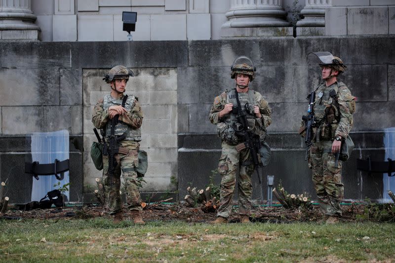 Members of the Wisconsin National Guard stand by as people gather for a vigil, following the police shooting of Jacob Blake, a Black man, in Kenosha, Wisconsin