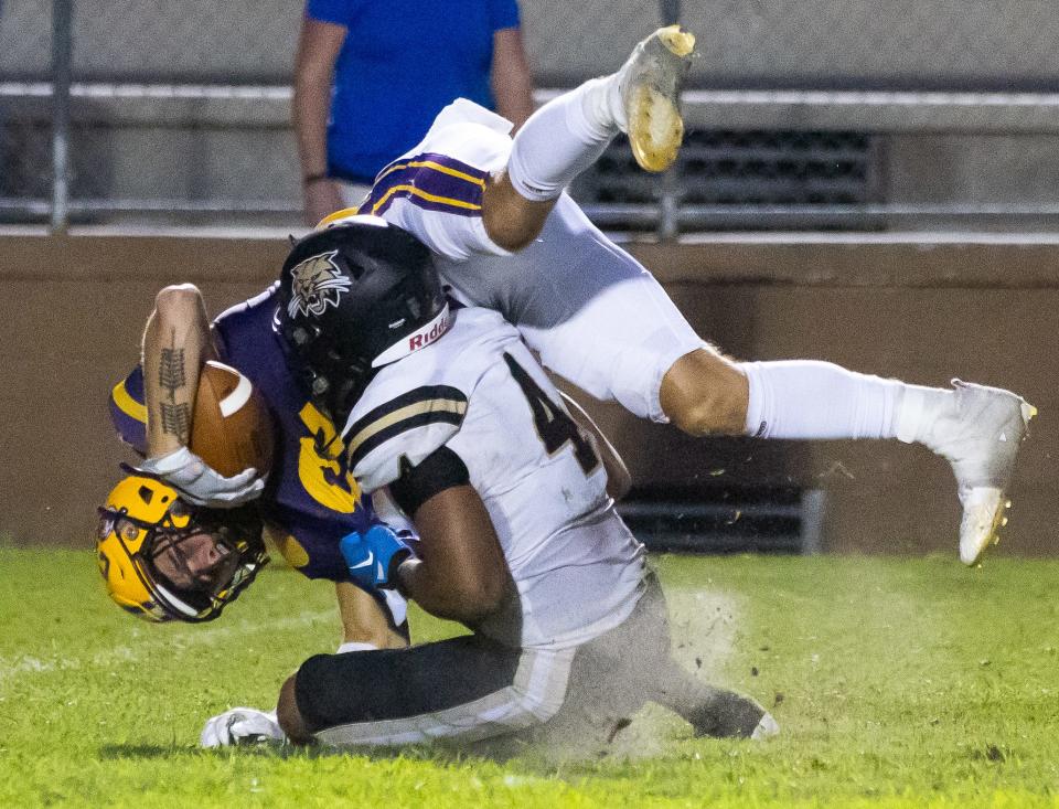 Columbia High School wide receiver Camdon Frier (12) is thrown to the ground by Buchholz (4) in the second half on fourth down. The Buchholz Bobcats hosted the Columbia Tigers at Citizens Field in Gainesville, FL on Saturday, August 26, 2023. The two teams had to reschedule the game after lightning and an incident that occurred at Columbia High School Friday night. They were able to complete one quarter with Buchholz leading 14-0 after the delay Friday night. [Doug Engle/Ocala Star Banner]