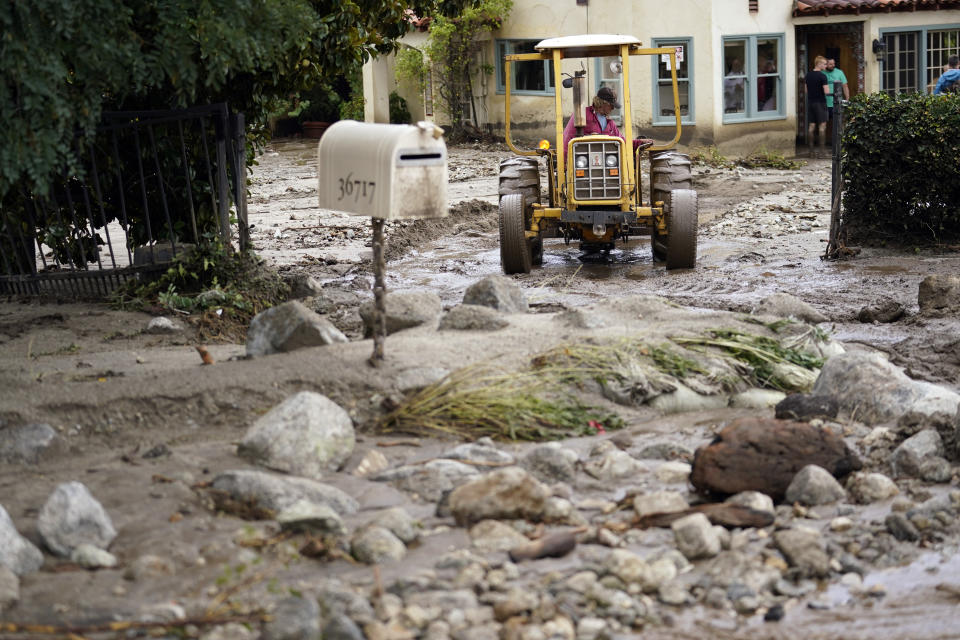 Resident Robbie Law uses a tractor to clear a neighbor's driveway in the aftermath of Tropical Storm Hilary Monday, Aug. 21, 2023, in Yucaipa, Calif. (AP Photo/Marcio Jose Sanchez)