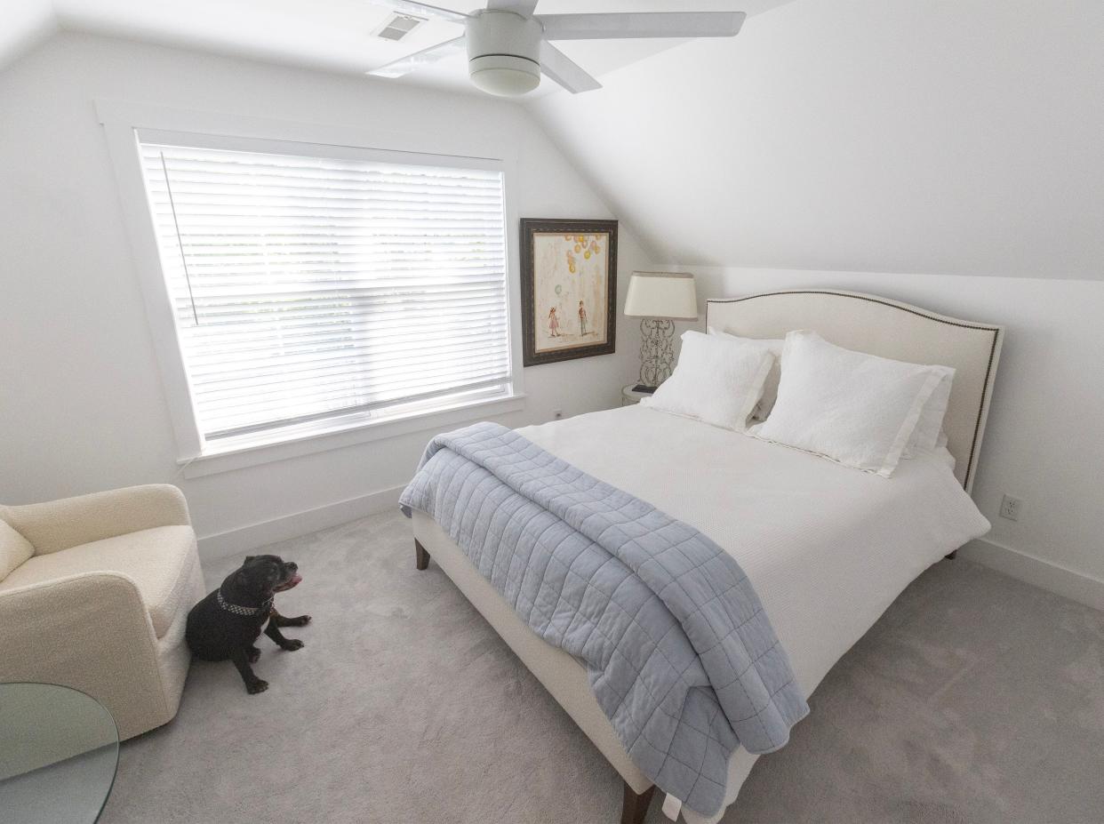 Kirby, a 10-year-old Staffordshire terrier, lounges in a second-story bedroom at the home of Sally Goodnow and Michael Kell. The room  shows Goodnow's preference for a color scheme dominated by white.