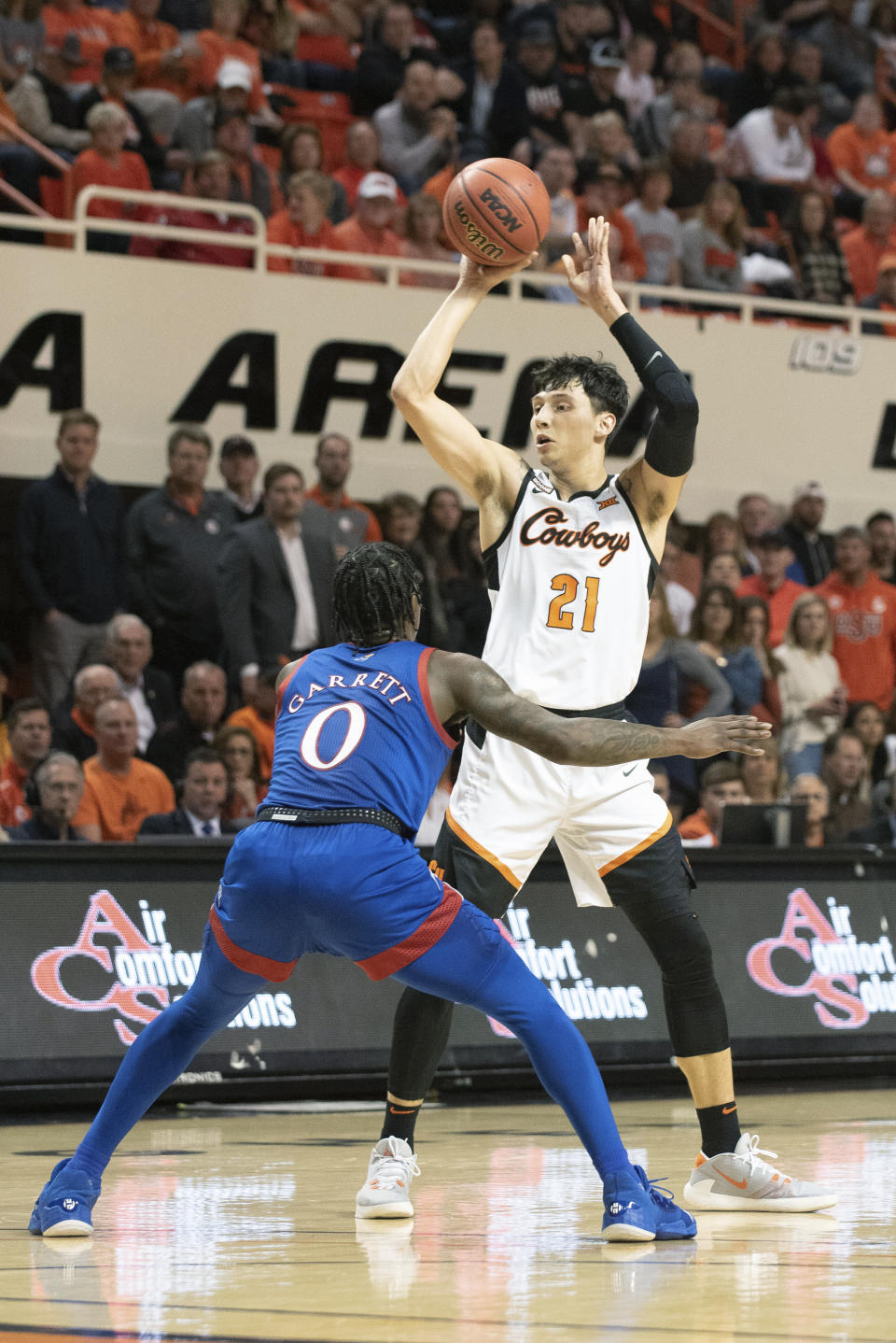 Oklahoma State guard Lindy Waters III (21) throws a pass over Kansas guard Marcus Garrett (0) during the first half of an NCAA college basketball game in Stillwater, Okla., Monday, Jan. 27, 2020. (AP Photo/Brody Schmidt)