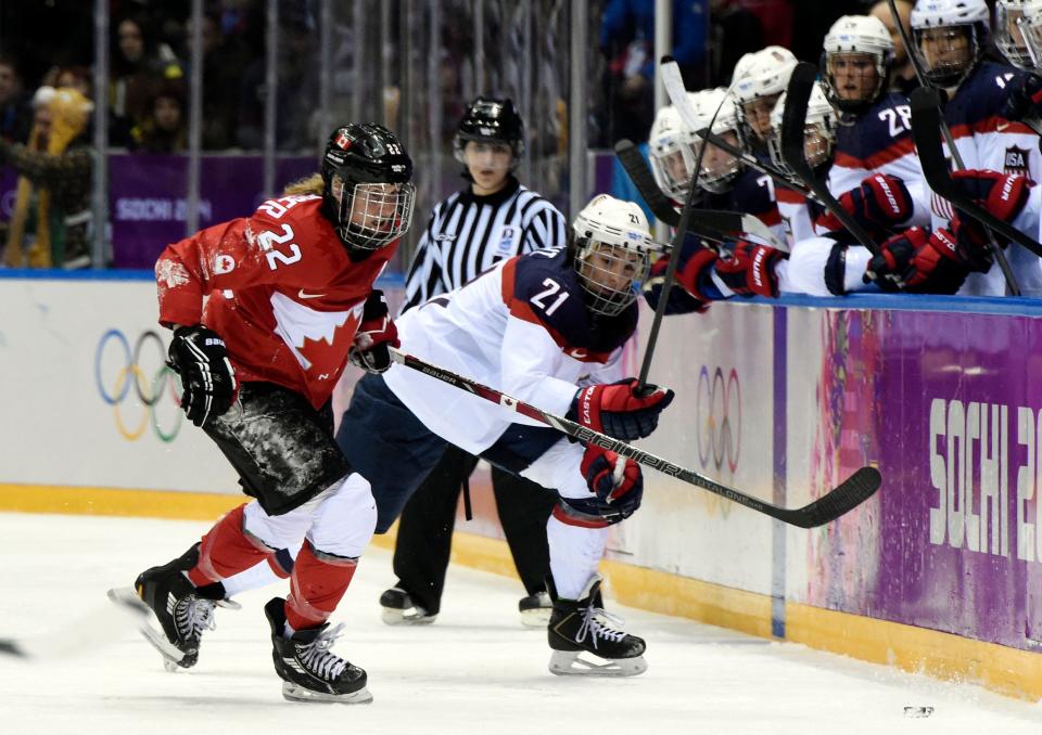 Feb 20, 2014; Sochi, RUSSIA; Canada forward Hayley Wickenheiser (22) battles for the puck with USA forward Hilary Knight (21) in the women's ice hockey gold medal game during the Sochi 2014 Olympic Winter Games at Bolshoy Ice Dome. Mandatory Credit: Scott Rovak-USA TODAY Sports