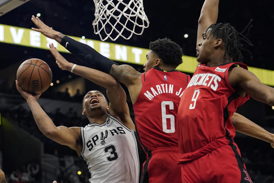 San Antonio Spurs forward Keldon Johnson (3) is pressured by Houston Rockets forward Kenyon Martin Jr. (6) and guard Josh Christopher (9) during the second half of an NBA basketball game, Wednesday, Jan. 12, 2022, in San Antonio. (AP Photo/Eric Gay)