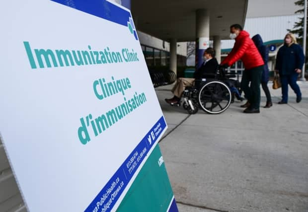 People arrive to be immunized at the Nepean Sportsplex last month. There are increasing calls to declare more regions in eastern Ontario COVID-19 hot spots, which could make vaccines more accessible. (Sean Kilpatrick/Canadian Press - image credit)