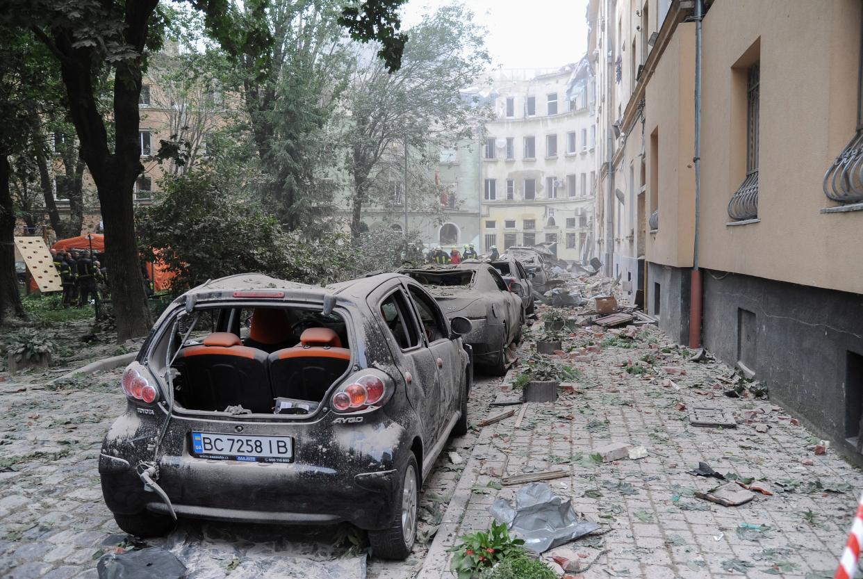 Damaged vehicles and debris line the street (EPA)