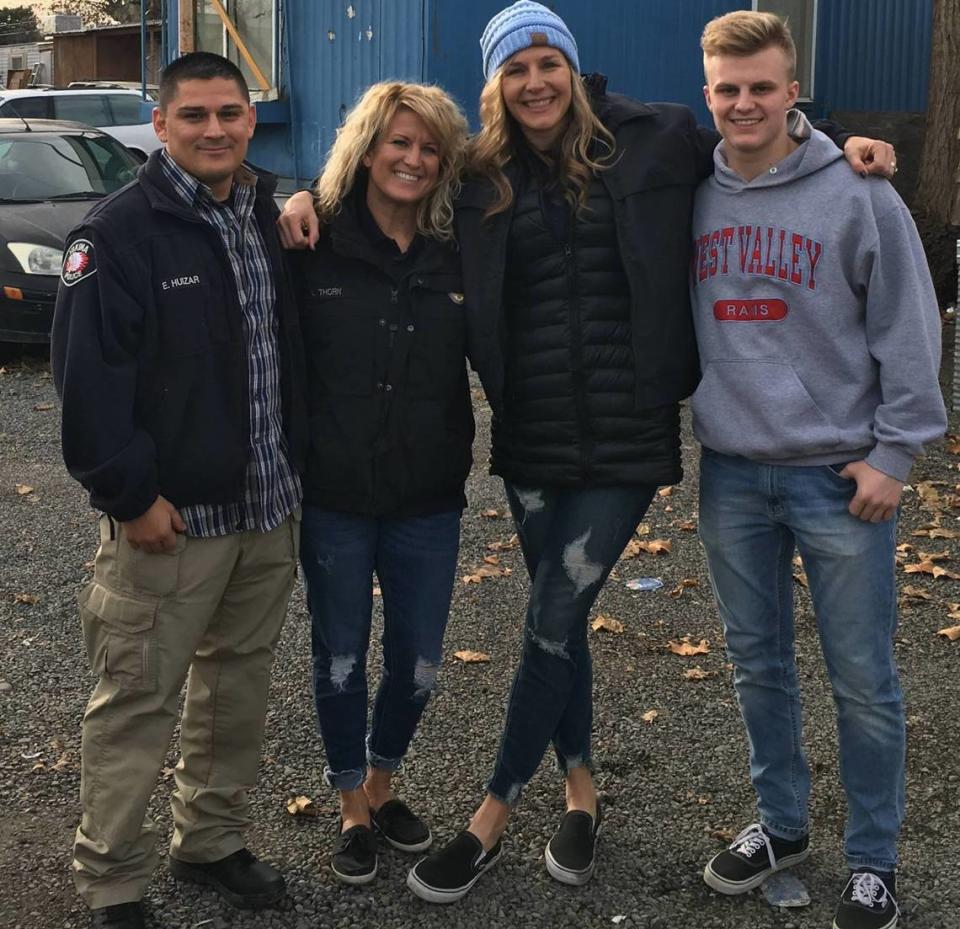 Former Yakima Police Officer Elias Huizar, on the left, is accused of raping a teen at a West Richland home. He is pictured here in 2018 with two other resource officers delivering food to families in need.