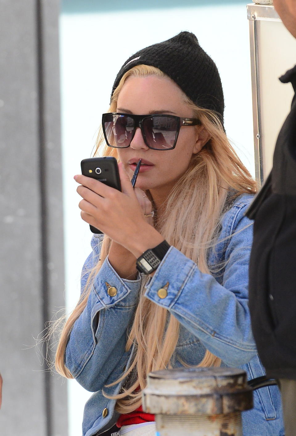 Amanda Bynes re-applying her lipstick outdoors