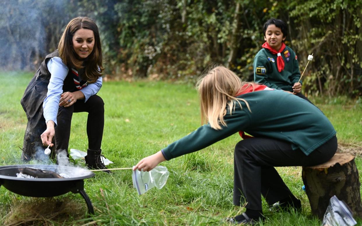 The Duchess of Cambridge toasts marshmallows during her visit to a Scout Group in Northolt - AFP