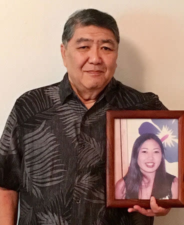 George Young holds a framed photo of his late daughter Tim Young in Hilo, Hawaii, U.S., July 30, 2018. Picture taken July 30, 2018. Courtesy Lynn Viale/Handout via REUTERS