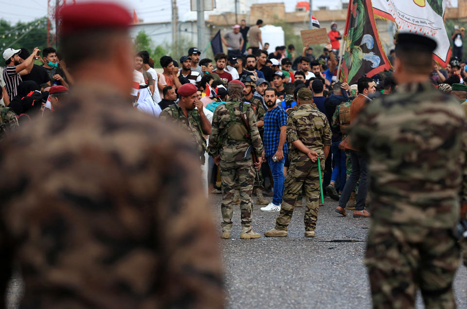 Iraqi security forces stand guard while anti-government protesters gather near Basra provincial council building during a demonstration in Basra, Iraq, Monday, Oct. 28, 2019. (AP Photo/Nabil al-Jurani)