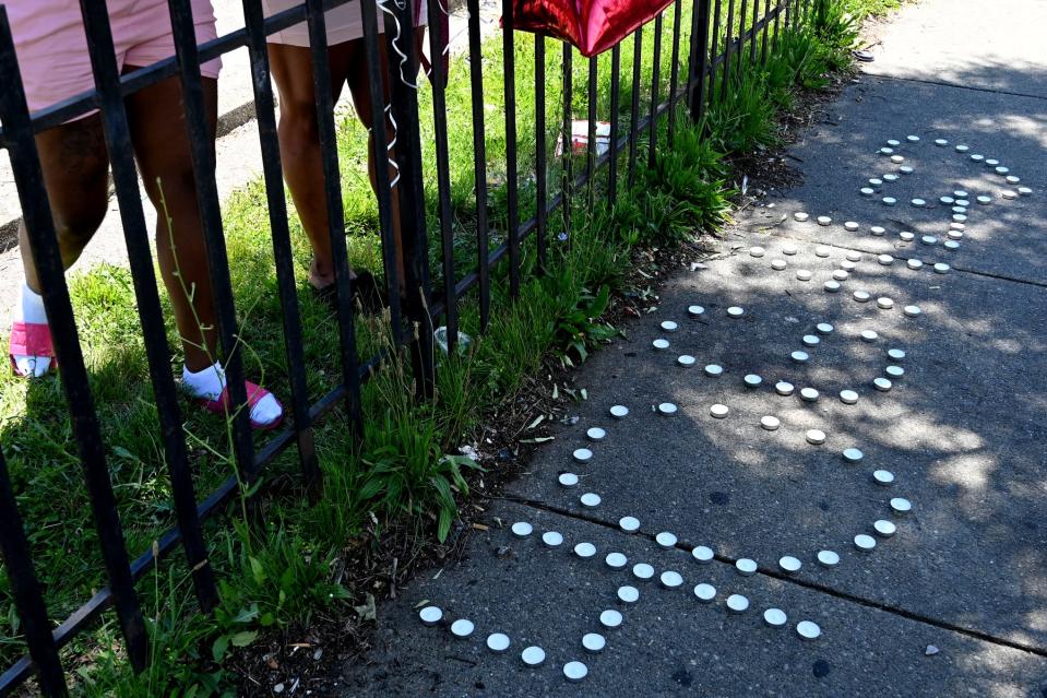 Friends lay gifts at a memorial after 16-year-old Galevon Beauchamp was killed June 21, 2021 in a drive-by shooting outside an Avondale Family Dollar. Cincinnati police arrested four other juveniles in connection with the death.