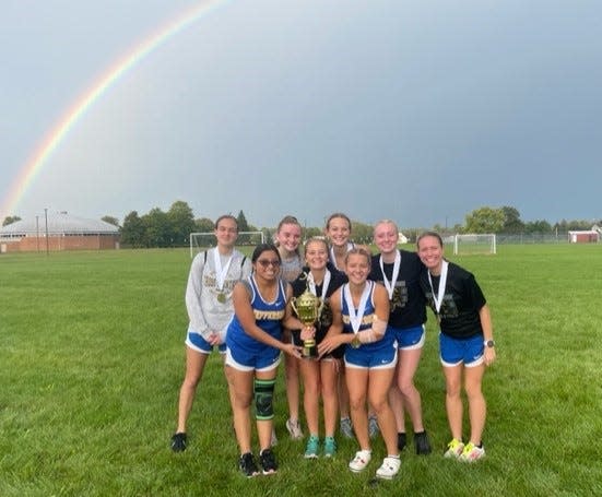 A rainbow rises over Jefferson's girls cross country team as it celebrates after winning the Milan Puddle Jumpers Invitational Tuesday.