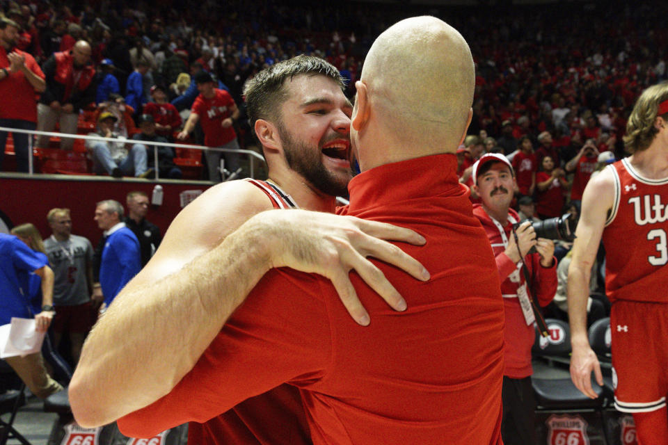 Utah guard Rollie Worster, left, hugs head coach Craig Smith, front right, after their victory over BYU in an NCAA college basketball game in Salt Lake City, Saturday, Dec. 9, 2023. (Megan Nielsen/The Deseret News via AP)