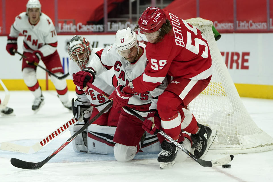 Carolina Hurricanes right wing Nino Niederreiter (21) defends Detroit Red Wings left wing Tyler Bertuzzi (59) in front of goaltender Petr Mrazek (34)in the second period of an NHL hockey game Saturday, Jan. 16, 2021, in Detroit. (AP Photo/Paul Sancya)