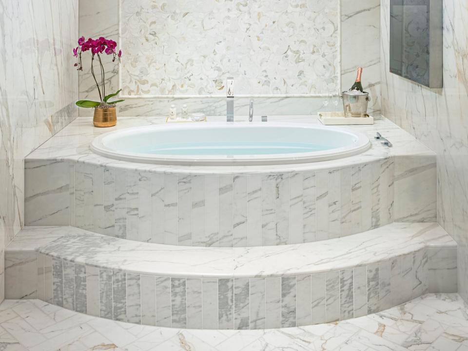 a large marble soaking tub under a skylight