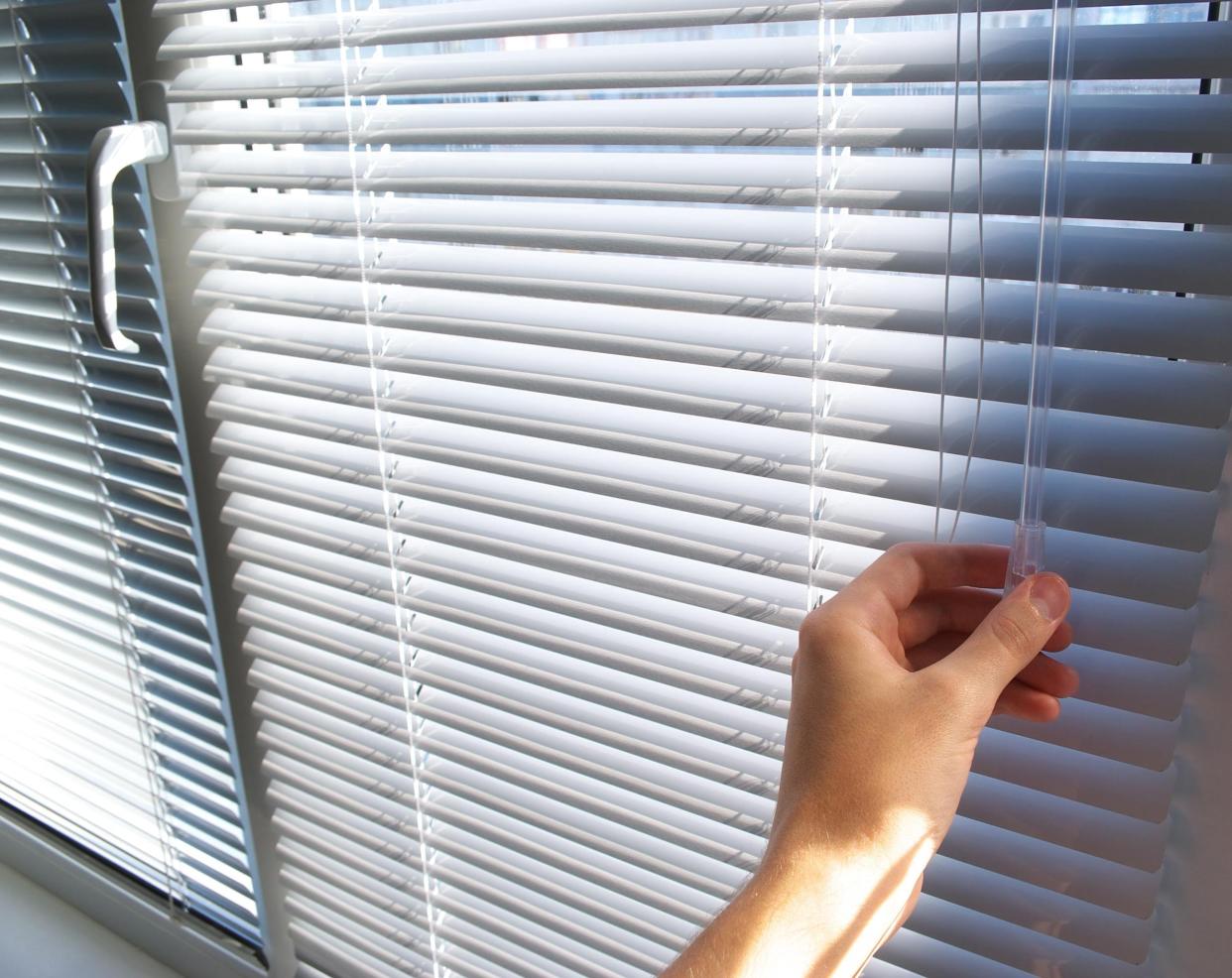 hand closing the blinds