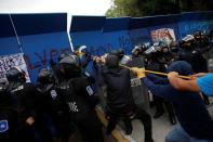 Police officers scuffle with protesters who want to topple the statue of Italian explorer Cristobal Colon, also known as Christopher Columbus, in Mexico City