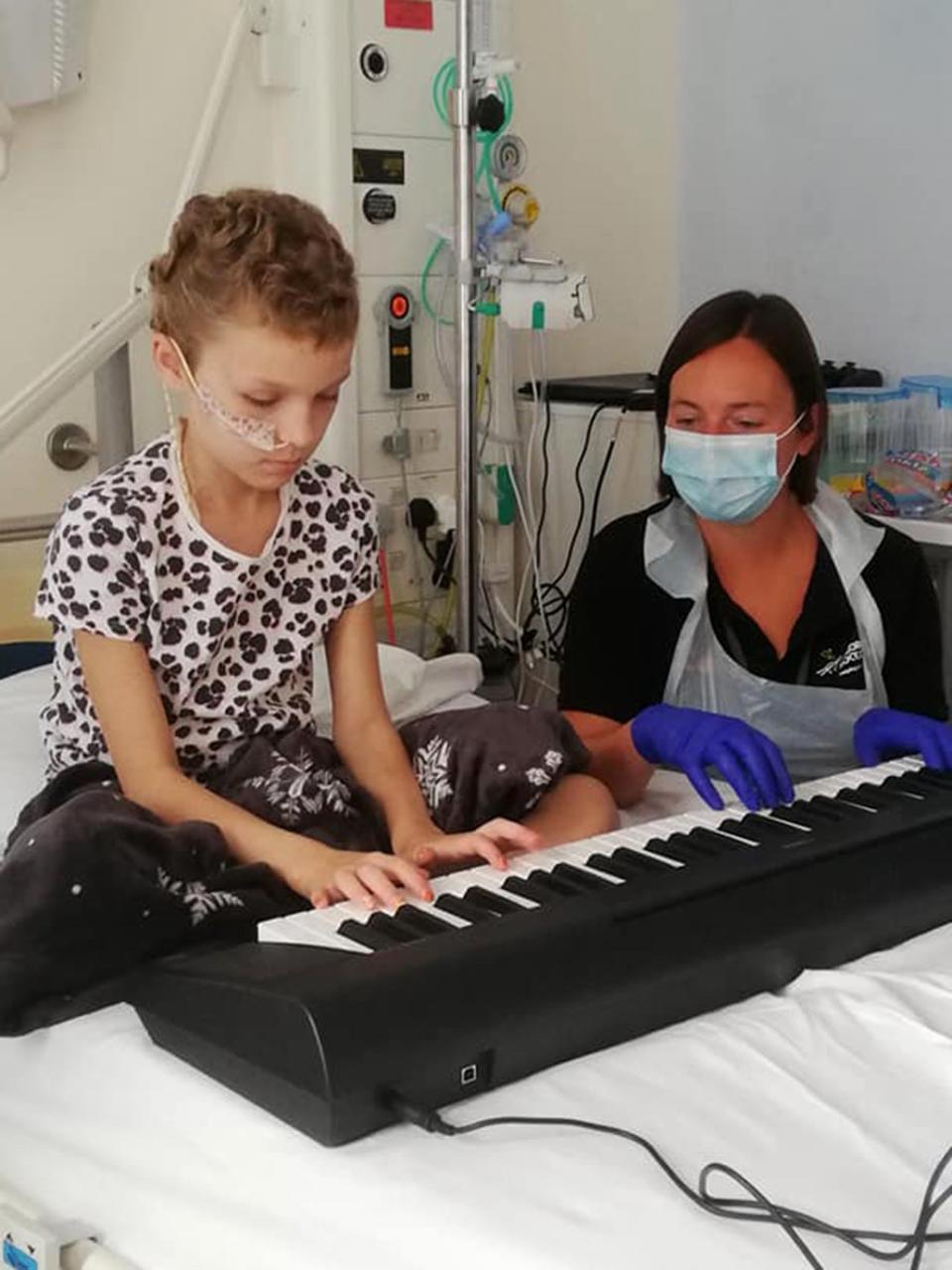 Sophie learns the piano with a hospital play assistant (Fairall Family)